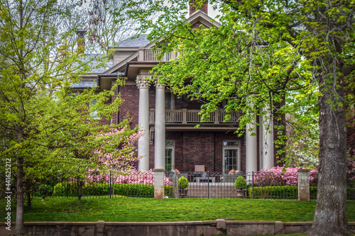 Photography Side of historical old home with ornate pillars and balconies in springtime with