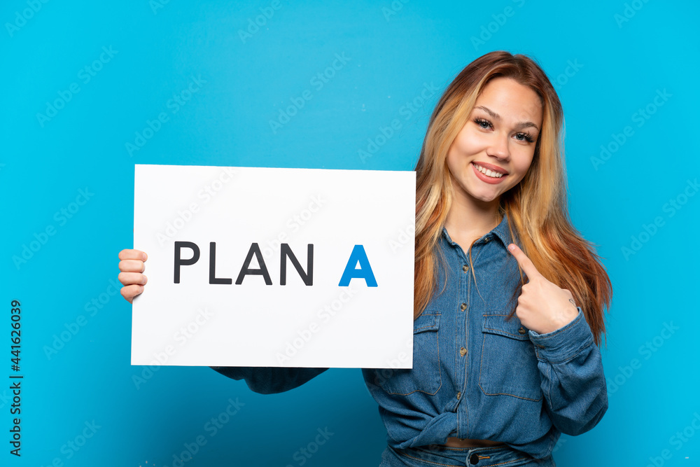 Teenager girl over isolated blue background holding a placard with the message PLAN A and pointing it Teenager girl over isolated blue background holding a placard with the message PLAN A and pointing it