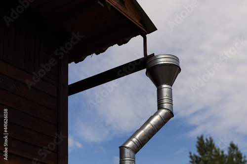 Roof edge of a small house with installed rainwater drainage system. rain gutter system