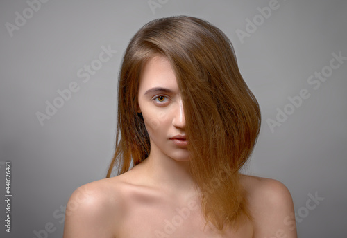 beautiful serious woman portrait, brunette staring at camera hair cover her half of face