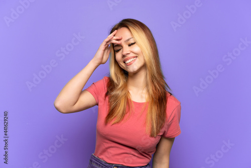 Teenager girl over isolated purple background smiling a lot