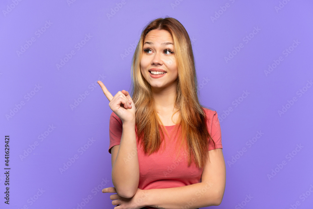 Teenager girl over isolated purple background intending to realizes the solution while lifting a finger up