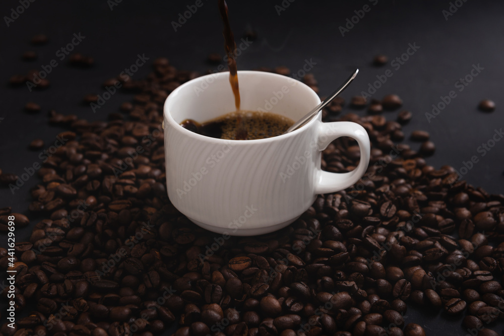 Pouring down some coffee on a cup isolated on coffee Pouring down some coffee on a cup isolated on coffee