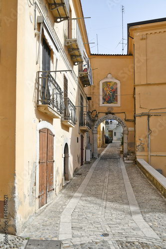 Fototapeta Naklejka Na Ścianę i Meble -  Candela, Italy, 06/21/2021. A small street between the old houses of a mediterranean village of Puglia region.