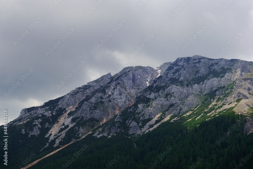 rocky high mountain with dense rain clouds detail