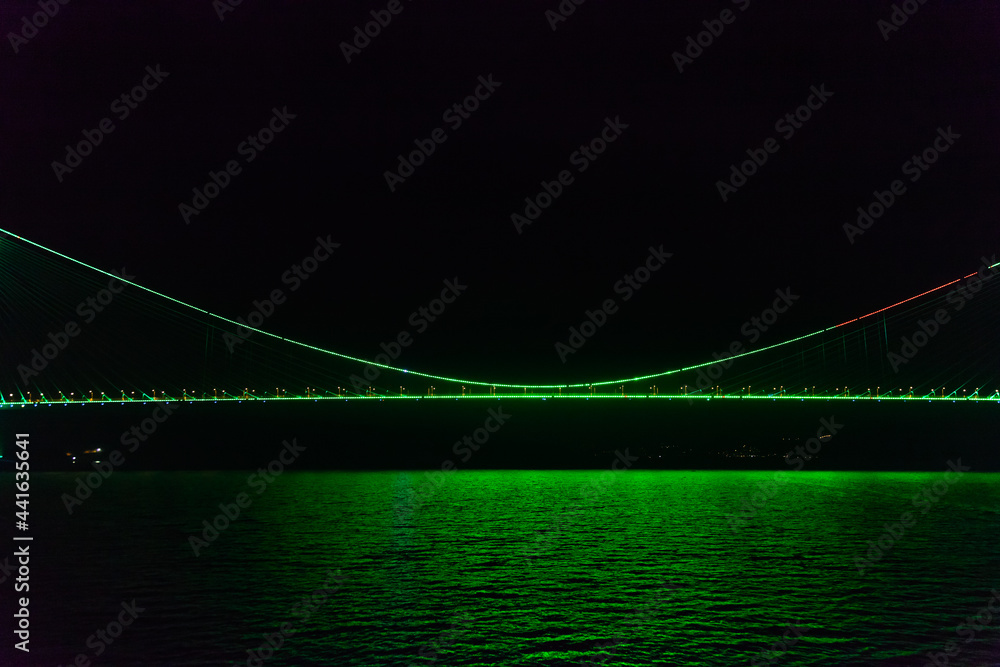 Night glowing bridge with water reflections, Bosphorus Strait, Istanbul Turkey.