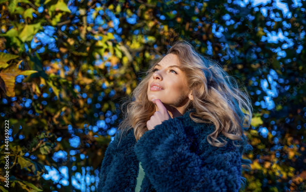 Pretty blond woman in warm faux fur coat for cold autumn weather outdoors, vogue Pretty blond woman in warm faux fur coat for cold autumn weather outdoors, vogue