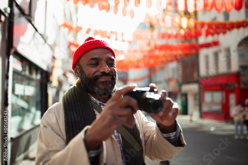 Male tourist with digital camera on street in Chinatown, London, UK photo