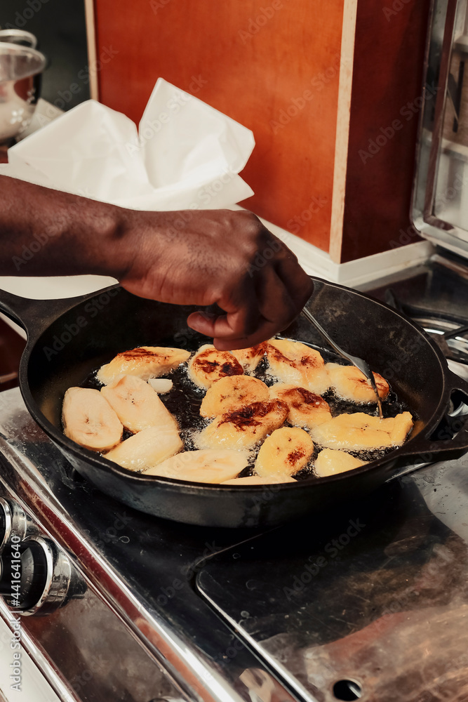 Home cook frying sweet plantains in oil on stove Home cook frying sweet plantains in oil on stove