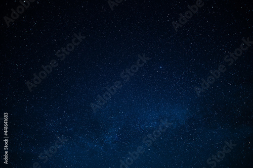 Night starry sky. Deep saturated dark blue color. Small stars twinkle far away in the sky. There is no one in the photo. There is a place for your signature. Background. Wallpaper. Texture.