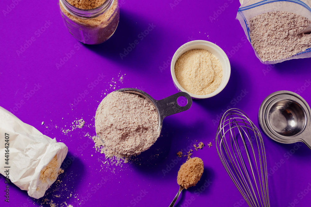 Baking ingredients and utensils on purple background Stock Photo