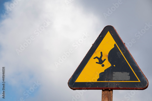 Warning sign of danger due to falling off a cliff due to landslides