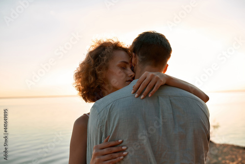Sensual young woman with man on beach at sunset