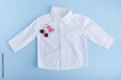 Juice stain with stain remover spray for clothes. Isolated on a blue background. top view. isolated on blue background