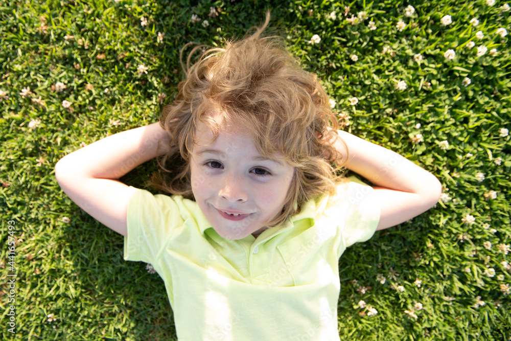 Kids enjoying summer. Children lying on grass portrait in summer nature park. Amazed surprised excited kids emotions. Kids enjoying summer. Children lying on grass portrait in summer nature park. Amazed surprised excited kids emotions.