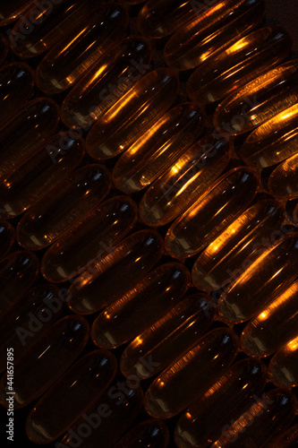 gold capsules under contrast lighting