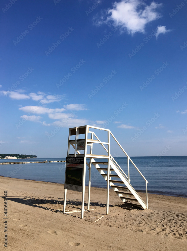 Empty lifeguard station on beach with blue sky and white clouds. Empty lifeguard station on beach with blue sky and white clouds.