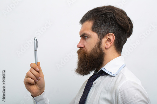 Business man in shirt and tie holding note pad and pen. Close up profile of surious man. Idea. Portrait of attractive intellectual business man thinking about notes. photo