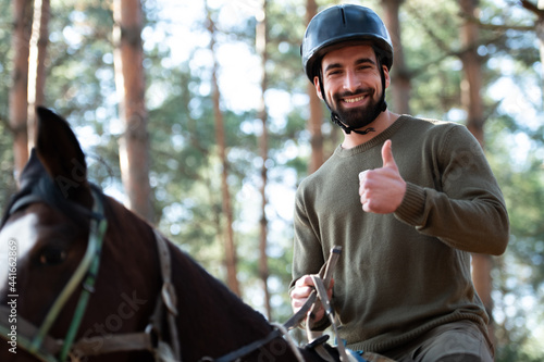 Man Riding a Horse and Showing Thumbs Up photo