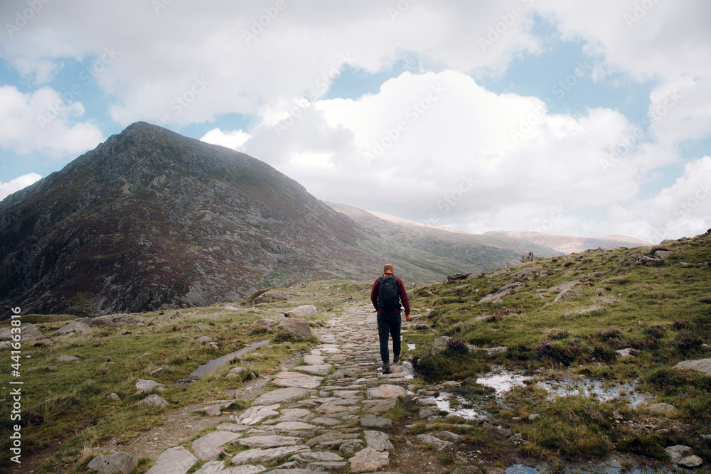 Anonymous traveler walking in hilly countryside