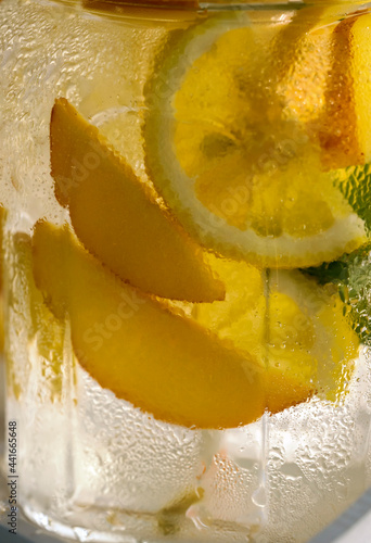 close-up of misted glass jar with citrus drink, abstract background