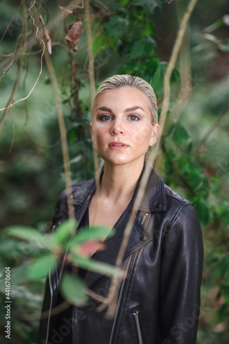 Tough Young Woman in a Black Leather Jacket Exploring a Forest Area