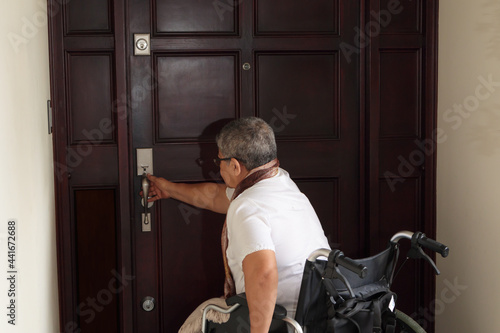 woman in a wheelchair opening the door