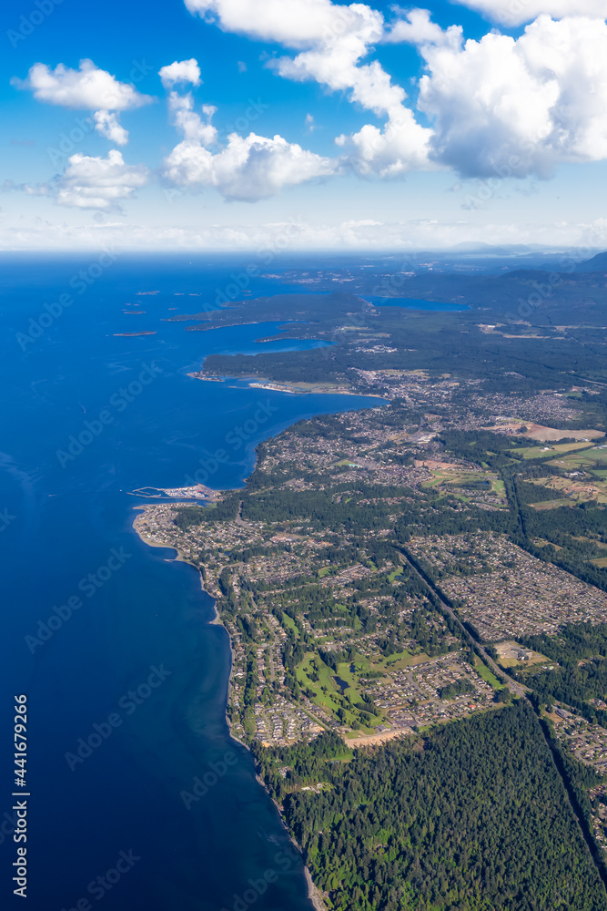 Fototapeta premium Aerial View of Qualicum Beach from an Airplane on the shore of Strait of Georgia in Vancouver Island, British Columbia, Canada. Colorful Blue Sky Art Render.