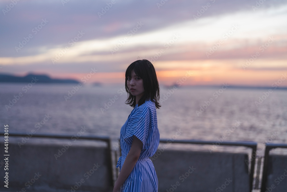 夕暮れの海にいる女性