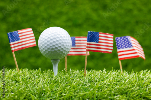 Golf ball with flag of America on green grass