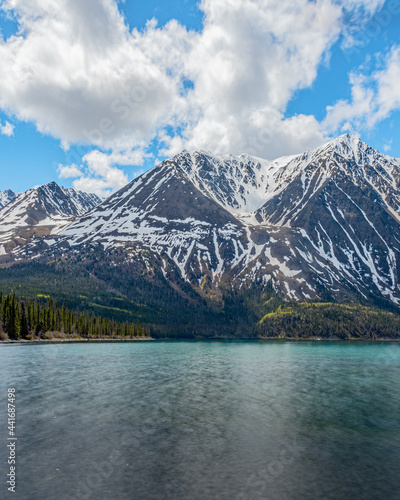 Stunning landscape beautiful view of Kathleen Lake in Yukon Territory, northern Canada with calm, pristine lake below snow capped mountain peaks in May, spring time.  © Scalia Media