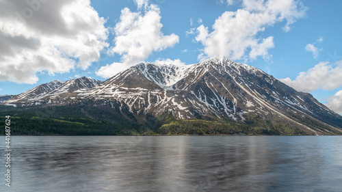 Stunning landscape beautiful view of Kathleen Lake in Yukon Territory  northern Canada with calm  pristine lake below snow capped mountain peaks in May  spring time. 