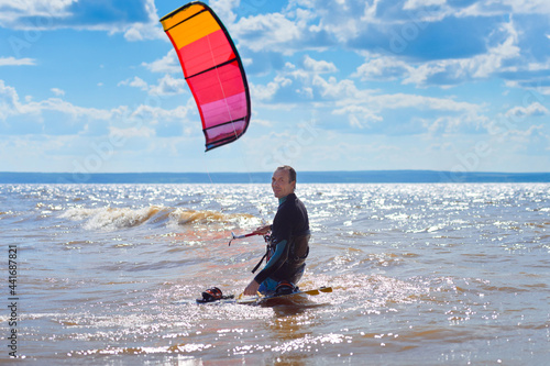 Canvas Print Kiteboarder surfing waves with kiteboard on a sunny summer day.