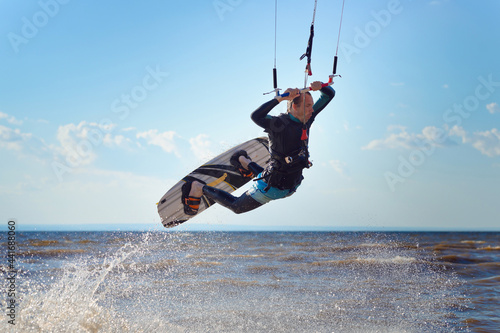 Photography Kiteboarder surfing waves with kiteboard on a sunny summer day.