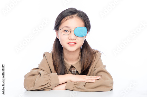 Little Asian girl with amblyopia on white background photo