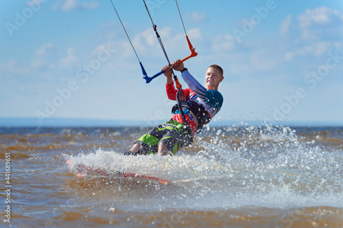 Photography Kiteboarder surfing waves with kiteboard on a sunny summer day.