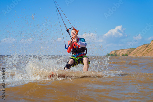 Photography Kiteboarder surfing waves with kiteboard on a sunny summer day.