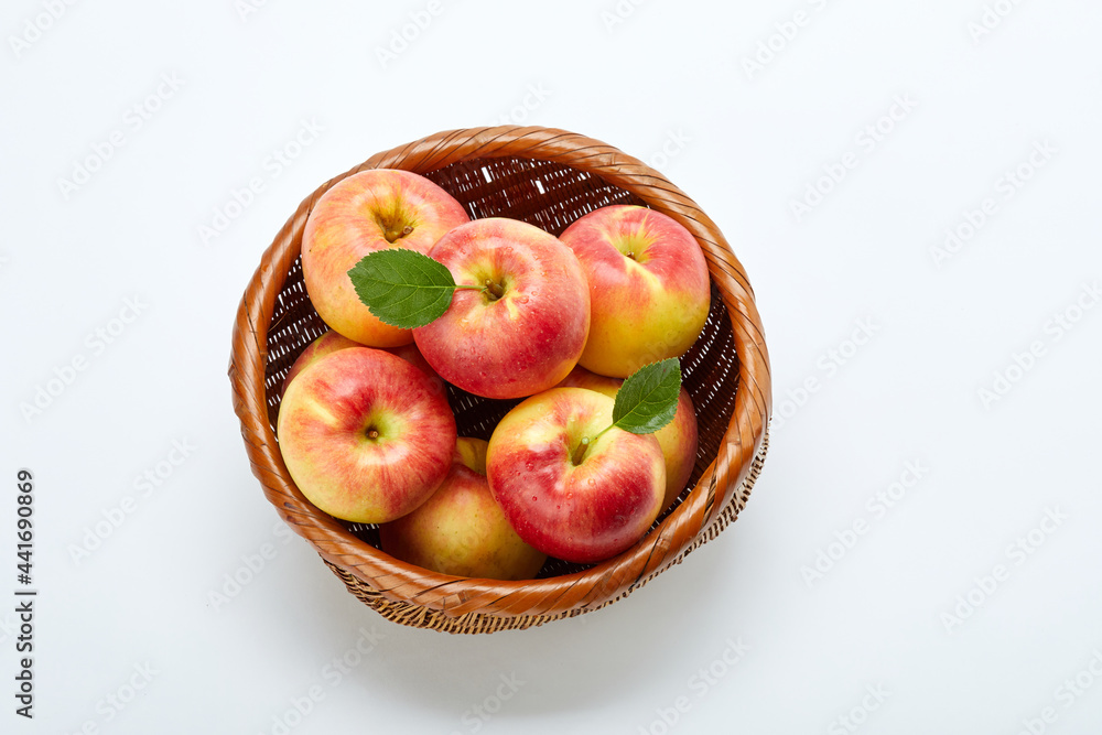 흰 배경 위의 바구니에 담긴 많은 사과. 