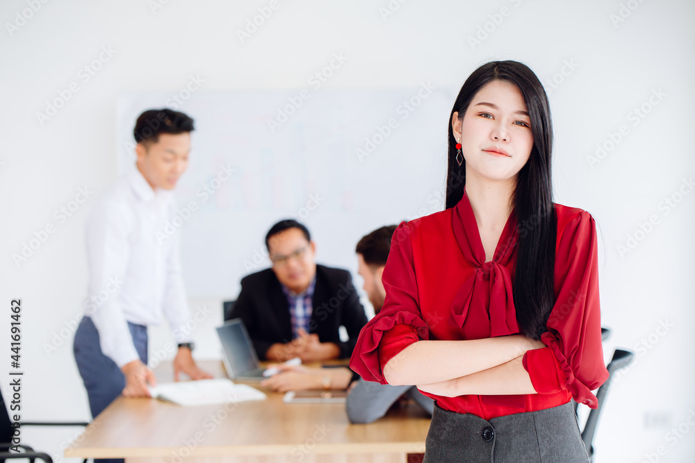 Young Asian business women leader executive standing confident working in office with team. Young Asian business women leader executive standing confident working in office with team.