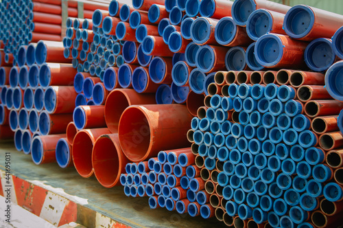 Red steel pipes for fire fighting system and extinguishing water lines in industrial building. Paint shop. Steel pipe of round industrial Steel Pipes bunch on a construction site © Chalermwoot