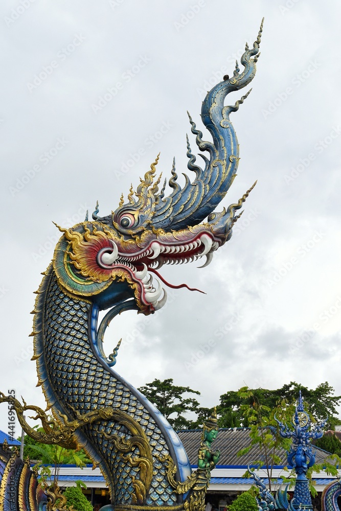 King of Nagas of Chiang Rai Blue Temple or Wat Rong Seua Ten, Thai folklore and streaks of metallic gold, all contributing to the temple’s magnificence. King of Nagas of Chiang Rai Blue Temple or Wat Rong Seua Ten, Thai folklore and streaks of metallic gold, all contributing to the temple’s magnificence.