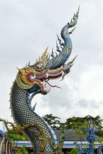 King of Nagas of Chiang Rai Blue Temple or Wat Rong Seua Ten, Thai folklore and streaks of metallic gold, all contributing to the temple’s magnificence. © PRANGKUL