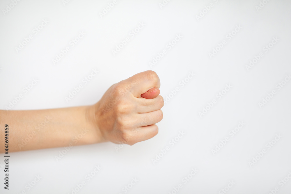 Female hand shows fig gesture, isolated on white background. 