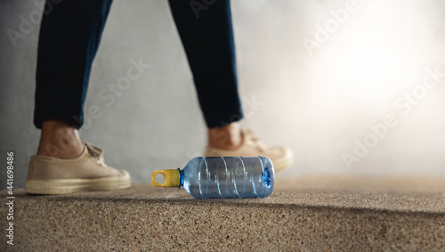 Environment, Ecology Care, Plastic Waste Problem Concept. Person Littering a Used Plastic Bottle into the Public Floor. Low angle view. focus on Bottle