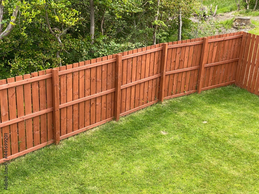 Wooden garden fence coated with medium oak colour paint Wooden garden fence coated with medium oak colour paint