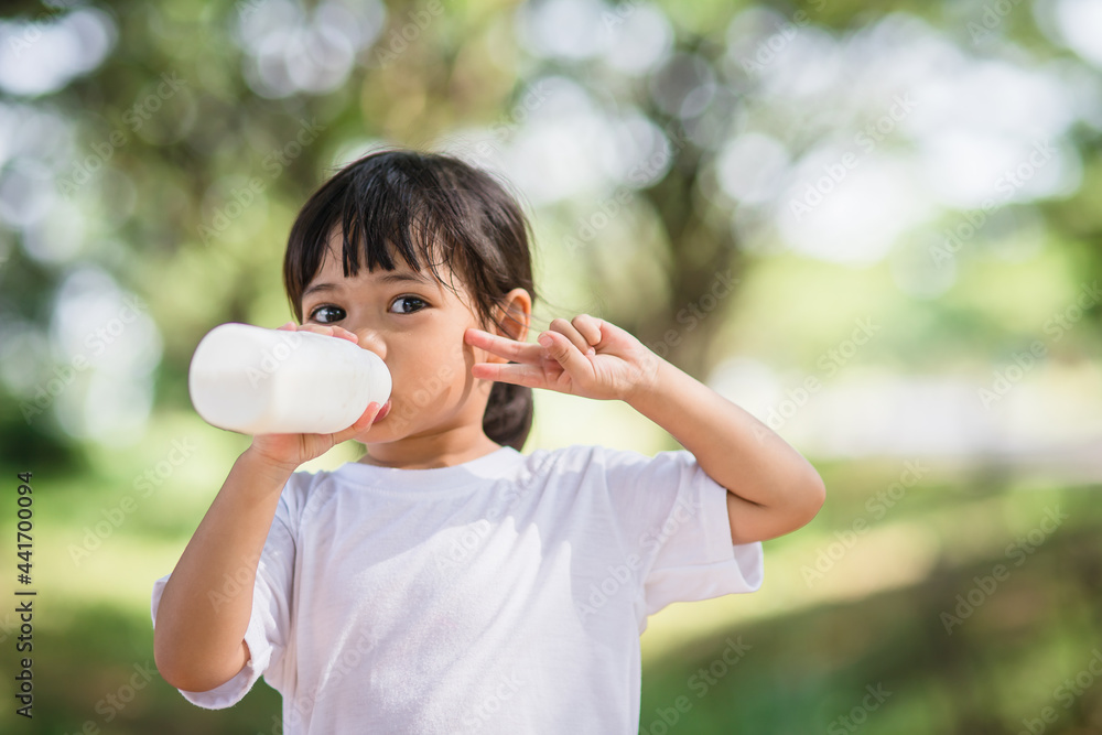 Cute asian little child girl is drinking a milk, soft focus Cute asian little child girl is drinking a milk, soft focus