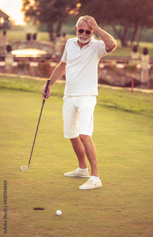 Obraz premium Senior man playing golf alone.