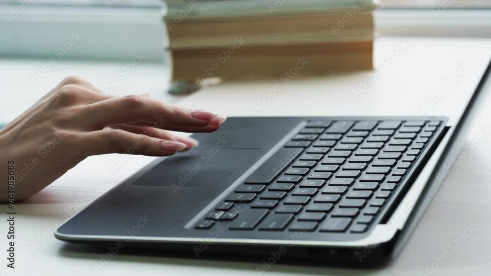 Internet business. Online work. Virtual office. Unrecognizable female freelancer hand using laptop touchpad scrolling at light home workplace. Internet business. Online work. Virtual office. Unrecognizable female freelancer hand using laptop touchpad scrolling at light home workplace.
