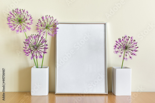 Composition with blank white oval frame and porcelein two white vases and summuer purple flowers.  photo