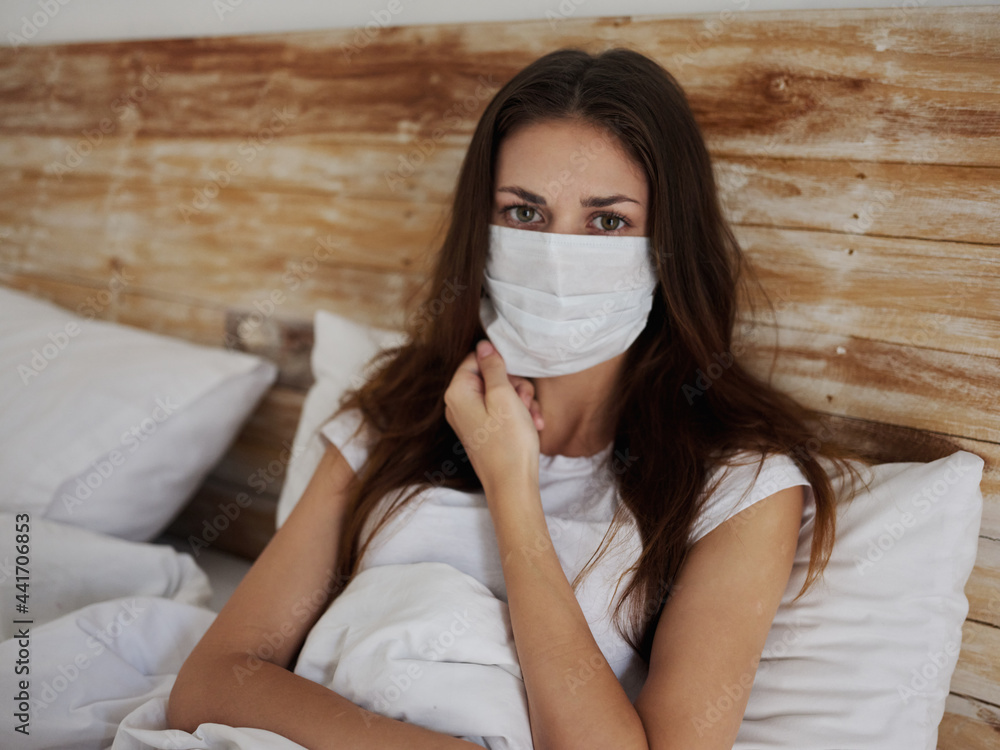 woman in medical mask lies in bed in quarantine pandemic coronavirus woman in medical mask lies in bed in quarantine pandemic coronavirus